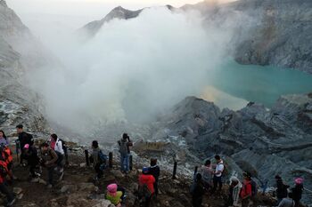 Wisatawan menikmati panorama kawah Gunung Ijen, di Banyuwangi, Jawa Timur, Sabtu (6/4/2019). Saat akhir pekan Gunung Ijen ramai dikunjungi wisatawan lokal maupun mancanegara diantaranya untuk melihat matahari terbit dan fenonema "blue fire" dari kawah gunung tersebut.