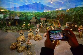 Wisatawan memotret diorama pekerja melakukan proses penjemuran tembakau dan kelobot di Museum Kretek, Kudus, Jawa Tengah, Senin (28/9/2020). Museum tersebut menyimpan koleksi mengenai sejarah terciptanya rokok kretek hingga proses produksi secara manual sampai menggunakan teknologi modern dan merupakan satu-satunya museum rokok yang ada di Indonesia.