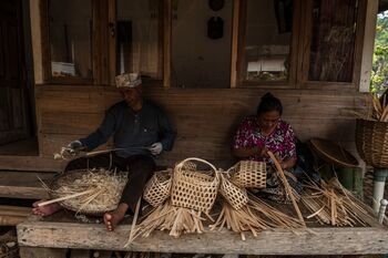 Endut Suganda dan Etin mengisi waktu luangnya dengan membuat aneka kerajinan dari bambu. Kerajinan ini menjadi buah tangan dari Kampung Naga dan memasok pasar hingga luar negeri. 