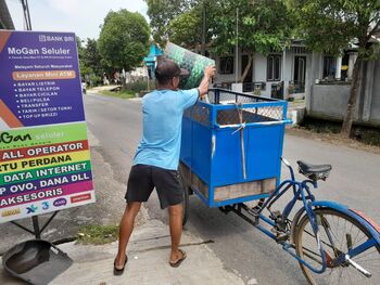 Salah satu pegawai pengelolaan sampah dari BUMDes Sapto Karyo Manunggal Mijen mengambil sampah warga (22/1/2023)