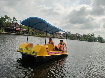 Pengunjung menaiki becak air, salah satu wahana yang disediakan BUMDes Ngemplak di wisata embung 'Rik Boe' (6/4/2023). 