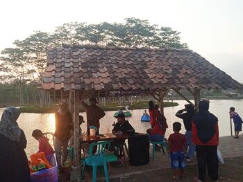 Masyarakat menikmati suasana teduh di kawasan wisata Rowo Gembongan, Kabupaten Temanggung, Jawa Tengah. 